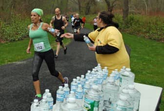 Denise Doktor, volunteer from the Goodwill Industries of RI hand out water at the first mile marker during the Rocky Point 5K on May 10, 2014.