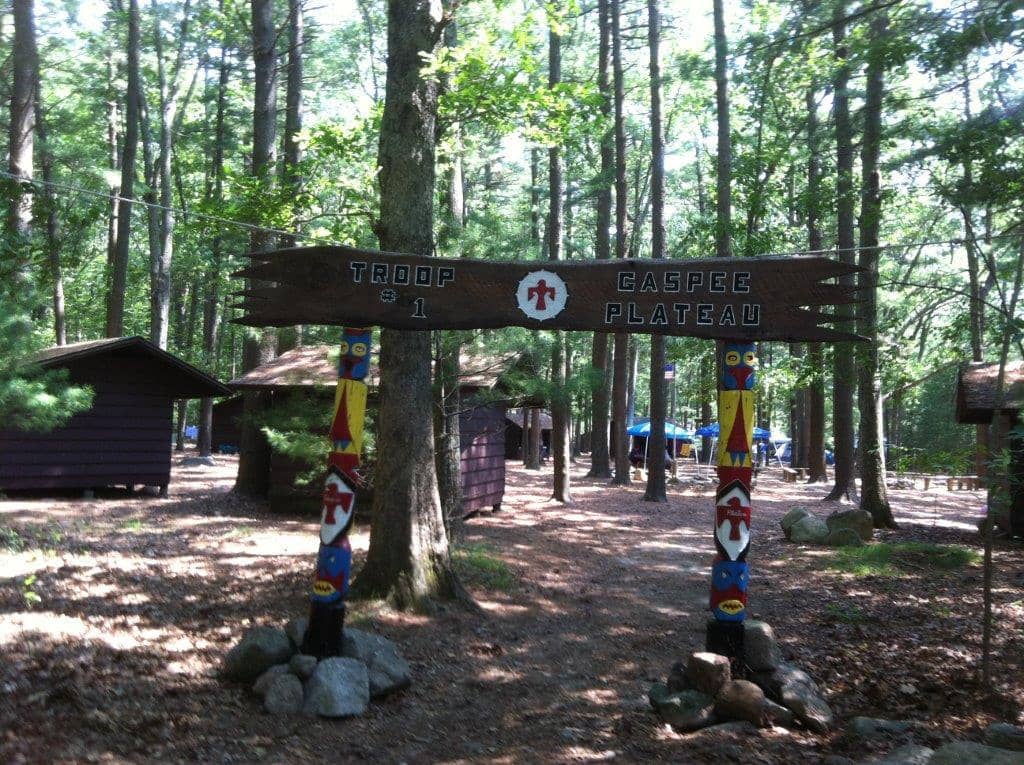  Jack Wallace, Everett McEwen and Harry Lefebvre, Jr. carved Troop 1 Gaspee Plateau's sign in Lefebvre's workshop. The sign, along with  totem poles, is still used by the Troop today.  Here, the poles and sign are posted outside Asbury United Methodist Church. Above, the sign and totem poles in use at Yawgoog, at the Dan Boone campsite.