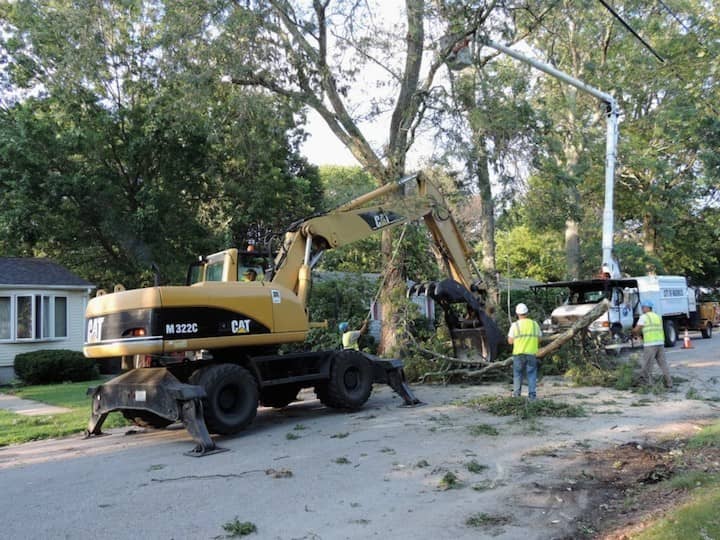 A cleanup crew uses heavy machinery to clear a downed tree in Lakewood, on South Atlantic Ave.