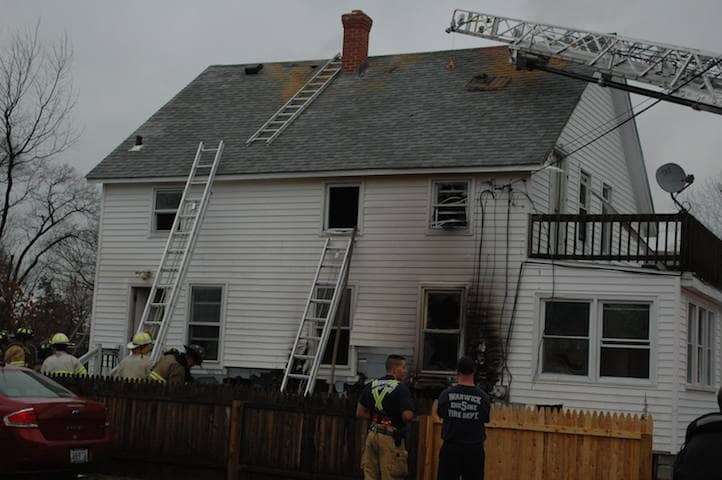 Firefighters run water lines into the second story at 39 Eaton Ave. Dec. 18.