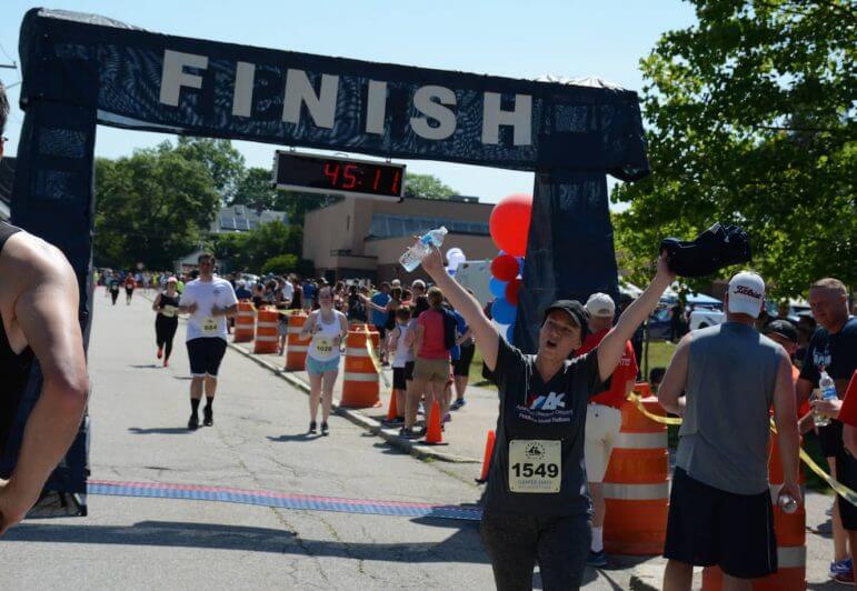 [CREDIT: Rob Borkowski]  Maureen Hoffman, 41, of Dayville, CT, celebrates fninishing the Gaspee Days 5K at 43:55.9.