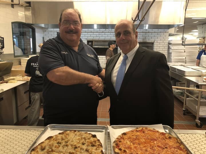 [CREDIT: Alyssa Stevens] Gary Bimonte, Grandson of Frank Pepe and Director of Quality Assurance & Training, and his family host an official ribbon cutting outside their new location in Warwick, the 10th for the brand. Incoming Mayor/City Council President Joseph Solomon and members of Warwick community joined in on the celebration.