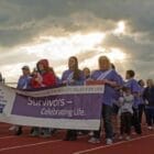 [CREDIT: Mary Carlos] Survivors of cancer march during a themed lap around West Warwick's High School track during the Relay for Life in 2017.
