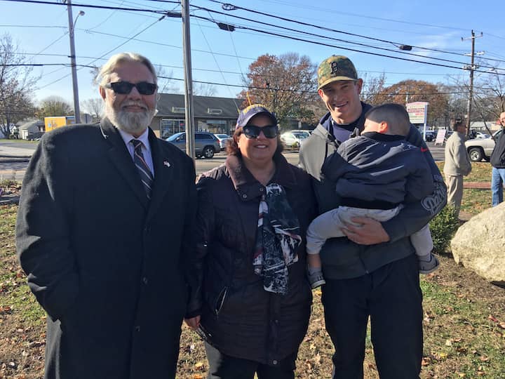 [CREDIT: Courtesy Kim Wineman] Members of the Rhode Island Military Organization (RIMO), local and state officials gathered Monday morning at Veterans Memorial Park to observe Veterans Day. From left, Reps. Dave Bennett, (D-Dist. 20), Camille Vella Wilkinson (D - Dist. 21) and Evan Shanley (D-Dist. 24) and his son, Max, 22 months old.