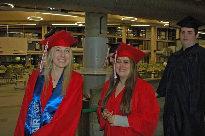 {CREDIT: Rob Borkowski] Savannah Cozza pauses for a smile as she heads toward the CCRI field house for graduation.
