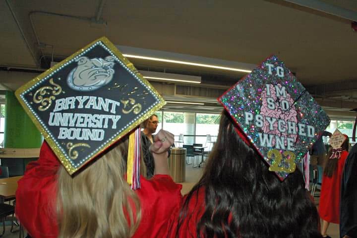 {CREDIT: Rob Borkowski] Brianna Jankowski and Madison Jackson show off their cap decorations on their way to graduation at CCRI June 6, 2019. 