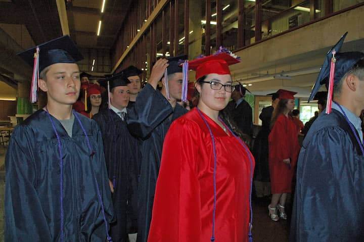 {CREDIT: Rob Borkowski] Michael Bastien, Jordan Beaumier, and Jazmine Barratt march toward the CCRI field house for graduation.