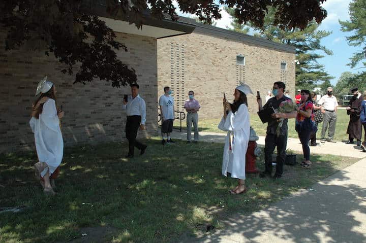[CREDIT: Rob Borkowski] Pilgrim High 2020 grad Diana Cepeda takes Casey Chamberlain's photo after receiving their diplomas June 4, 2020.