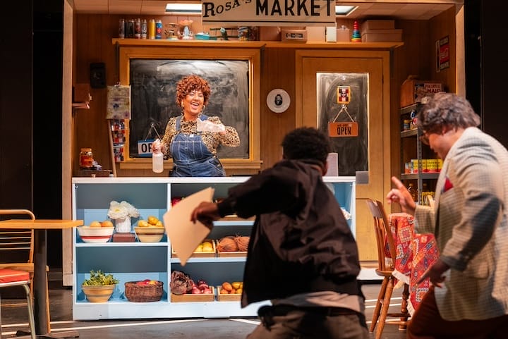 [CREDIT: Marisa Lenardson] Marina Tejada asRosita, with Jeff Ararat, and Rudy Cabrera, in aa shop scene during Trinity's 'La Broa’ (Broad Street).