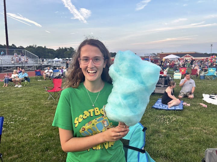 [CREDIT: Natalie Ferland] Coventry resident Kaleigh enjoys cotton candy from one of the vendors at the Summer Festival.