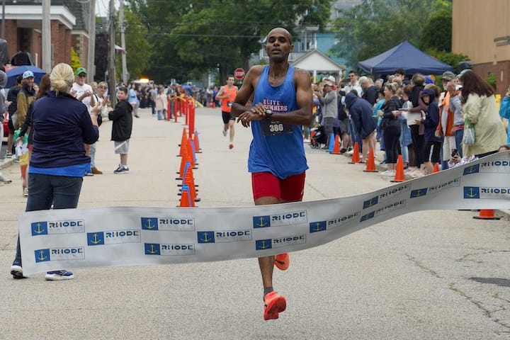 [CREDIT: Laura Paton] Gilmar Silvestre of Tauton MA crosses the end line first with a time of 14:20 throughout the June 14 Gaspee Days 5k.
